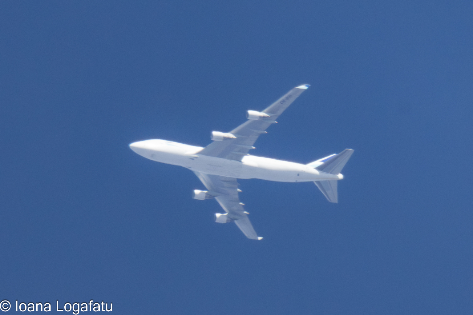 Clouds part to show a soaring plane